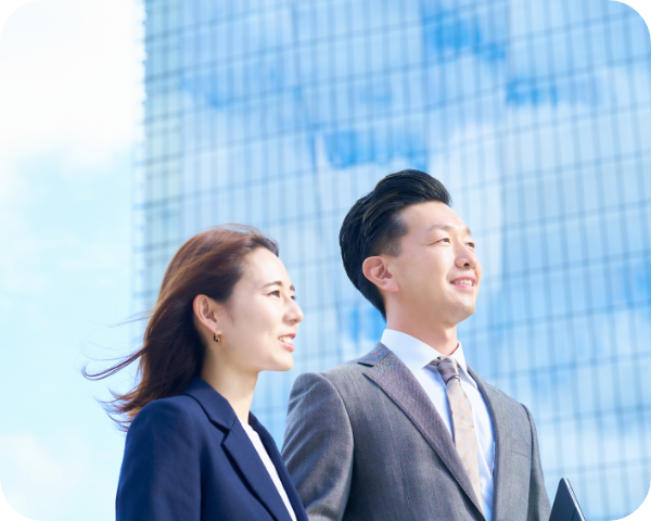 画像：スーツ姿の男女二人が画像左側を向きながら談笑している